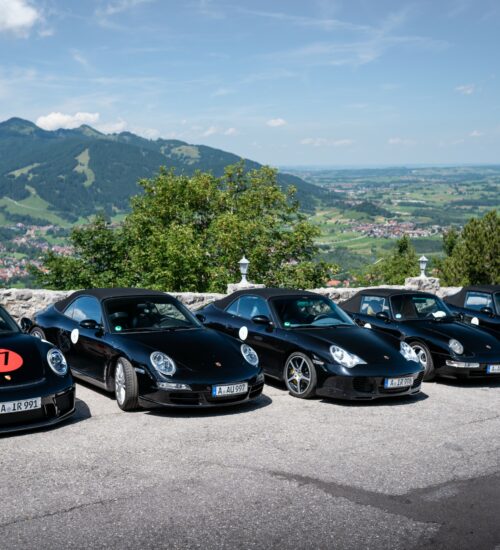 Porsche 911er stehen nebeneinander auf einem Parkplatz
