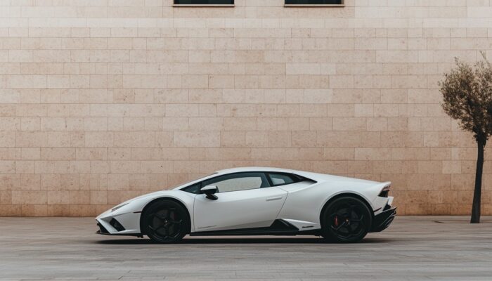 Ein weißer Lamborghini steht vor einer Wand